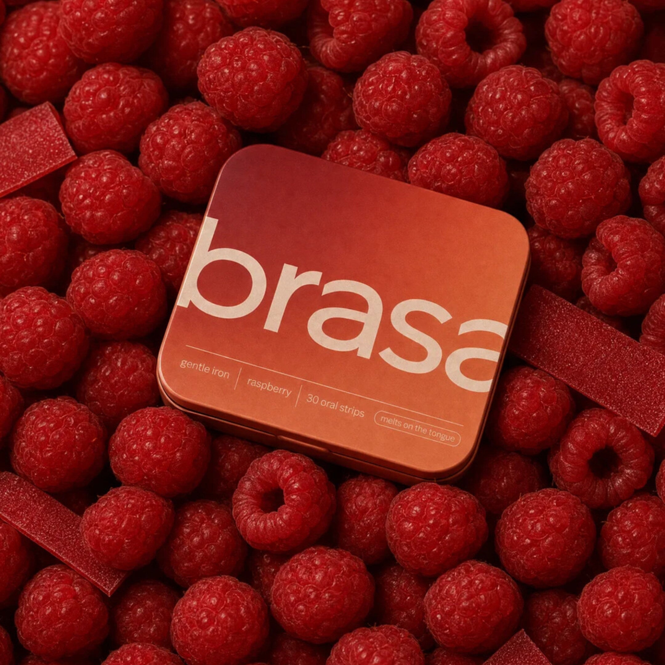 brasa gentle iron oral strips tin resting on fresh raspberries